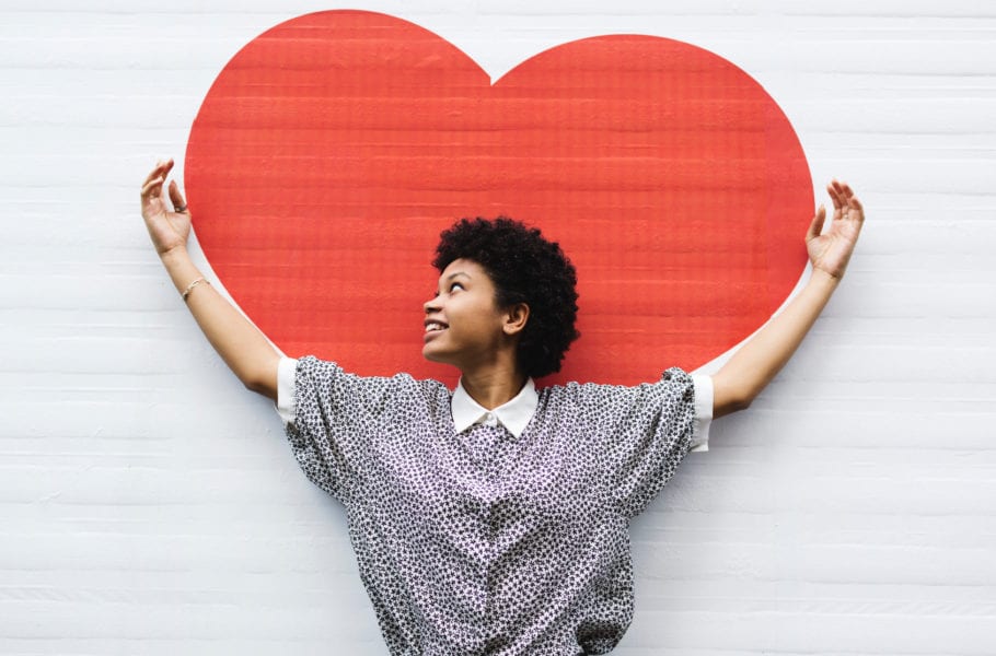 Candid Young Woman With Arms Raised To A Heart Drawn On The Wall