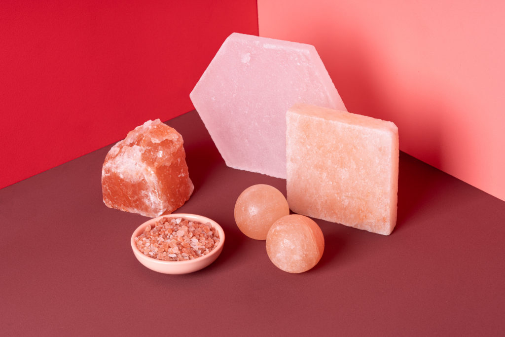 Various Shapes of Himalayan Salt on Red Colored Background.