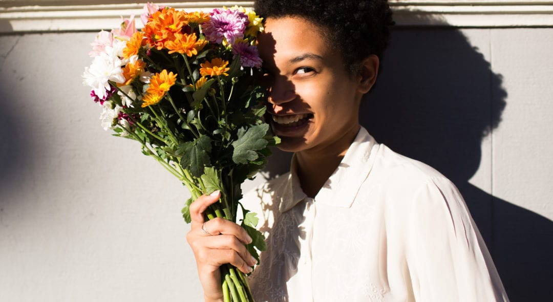 Smiling woman holding a bouquet of flowers.