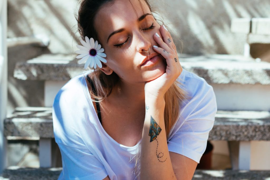 Young woman with eyes closed, relaxing in her garden