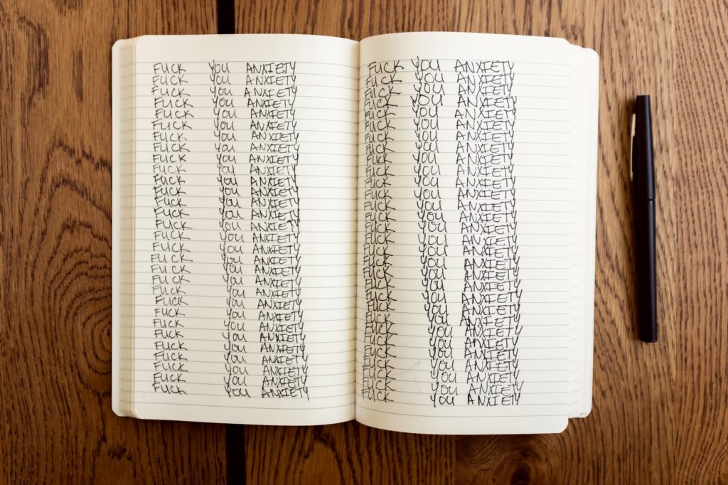 Young female journaling about her struggle with anxiety