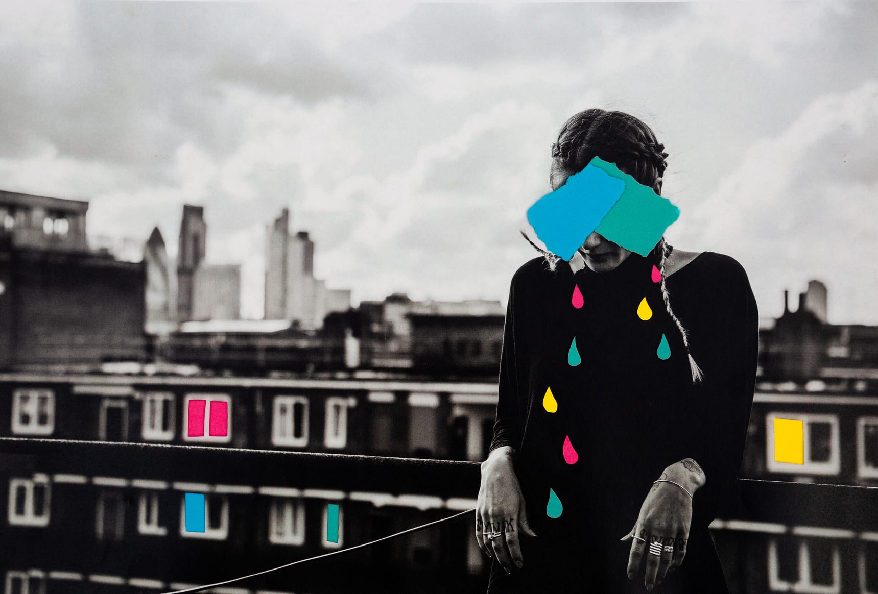 Mixed media analogue collage portrait of an anonymous woman on a rooftop with color blocked tears in blue, teal, pink and yellow, behind her the windows of flats are also color blocked.