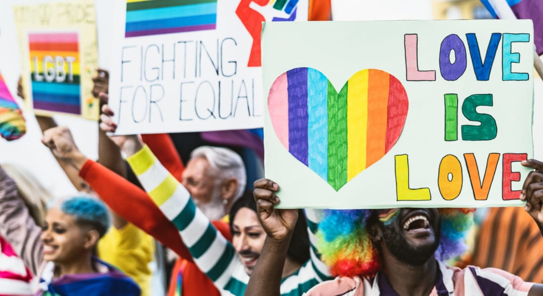 Happy Multiracial people celebrating gay pride event - Group of friends with different age and race fighting for gender equality rights