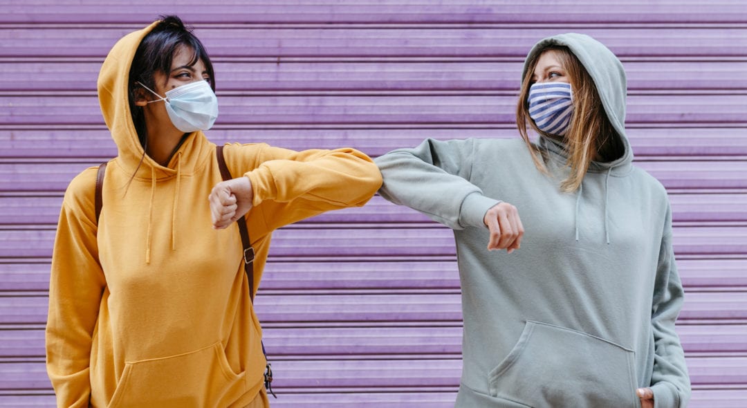 Portrait of two female friends with face mask keeping safety distance in Granada, Spain. urban young sweatshirt hood city convid19 "new normality" "social distance" (Portrait of two female friends with face mask keeping safety distance in Granada, Spa