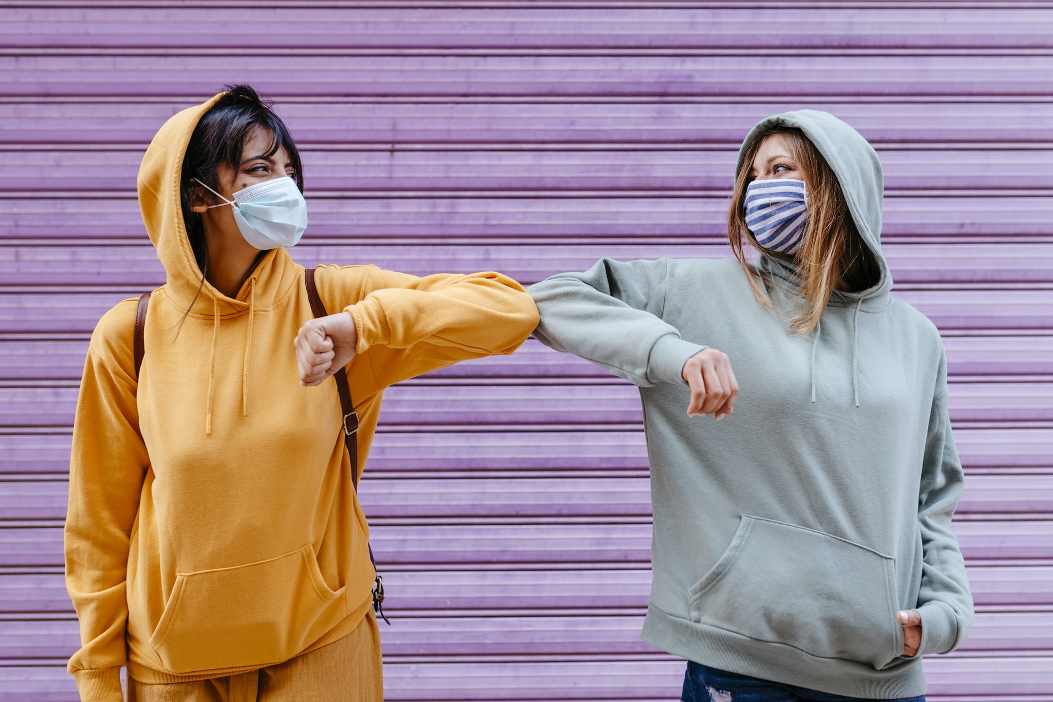 Portrait of two female friends with face mask keeping safety distance in Granada, Spain. urban young sweatshirt hood city convid19 "new normality" "social distance" (Portrait of two female friends with face mask keeping safety distance in Granada, Spa