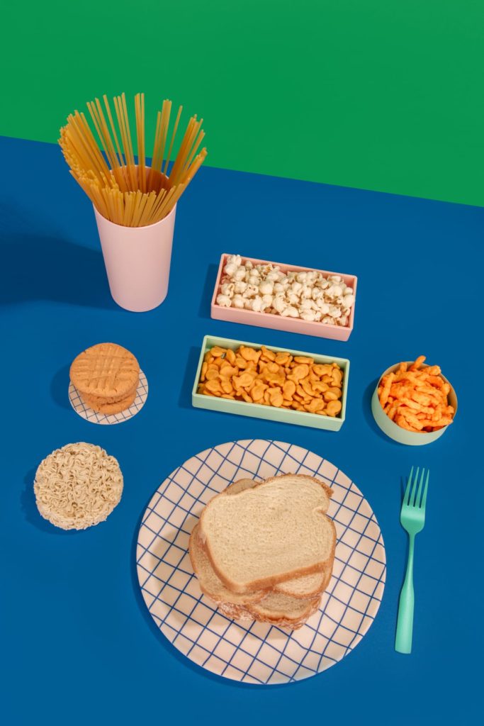 variety of processed foods/carbs against colorful backdrop