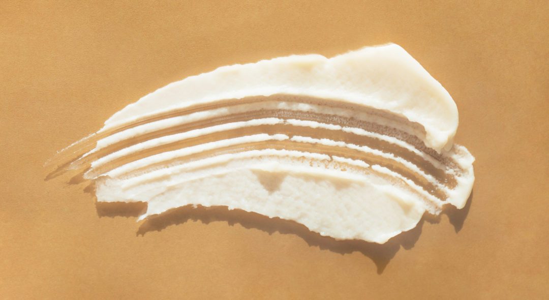 White textured smear of cream on beige background. Selfcare is a trendy procedure of the year