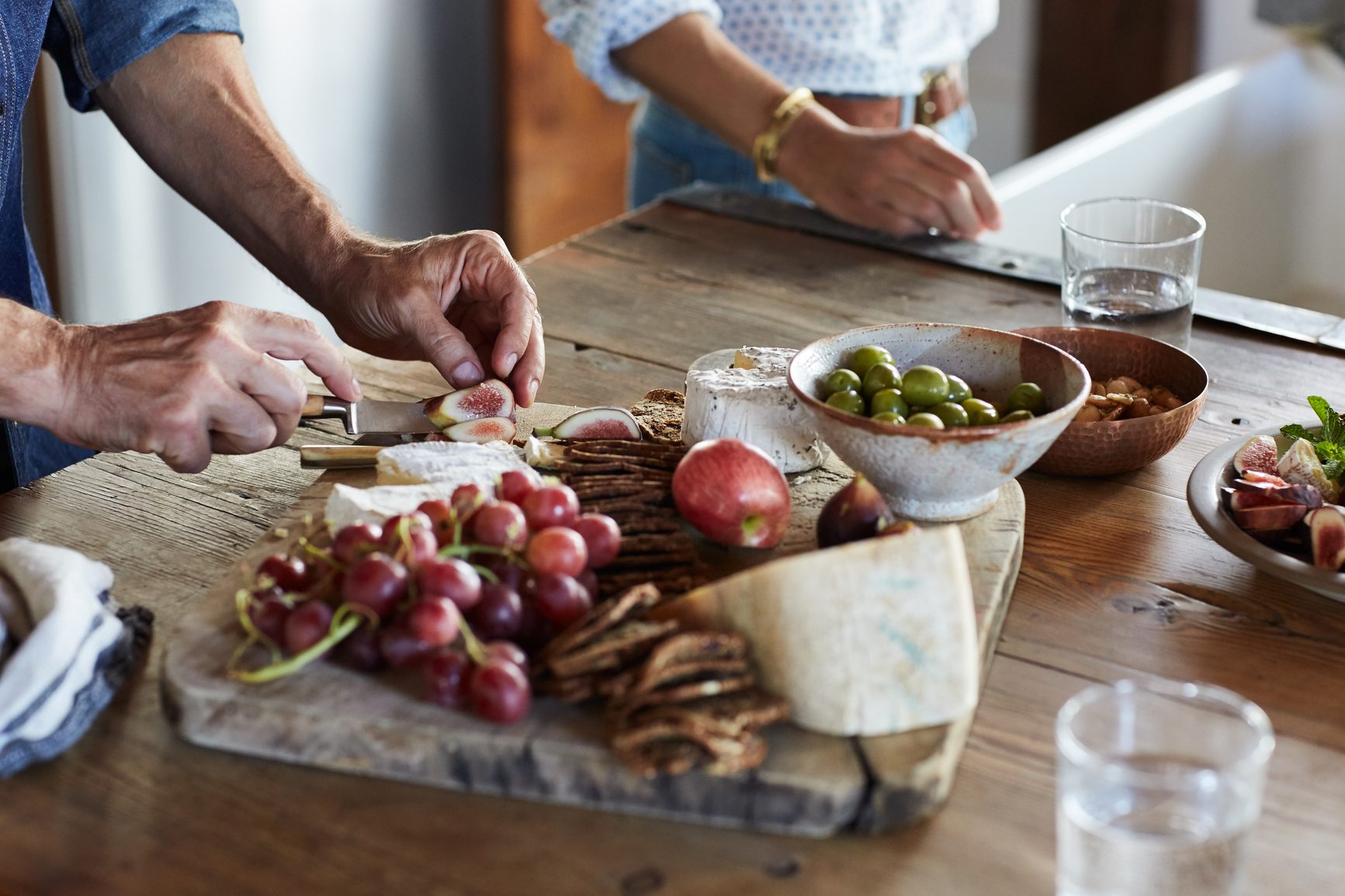 Couple making a cheese plate in the kitchen in a farmhouse