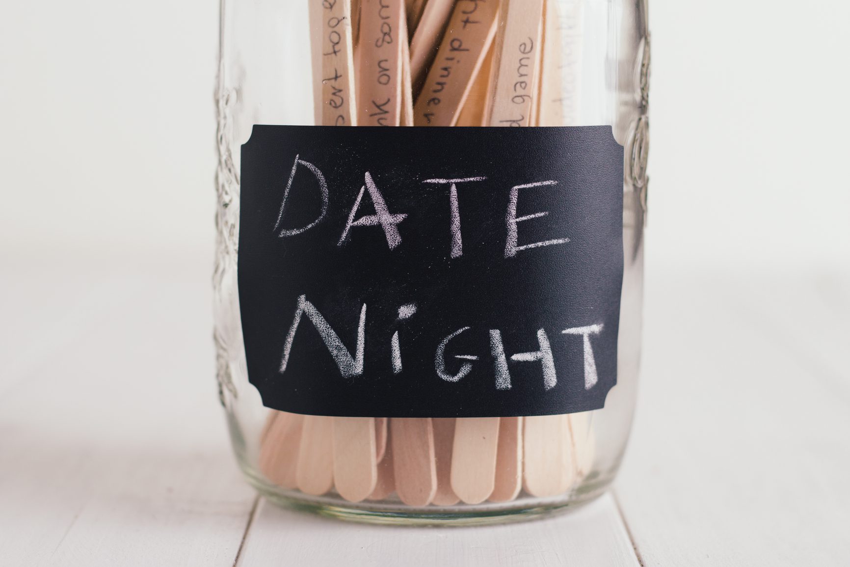 Jar containing wooden sticks with date nights ideas written on them