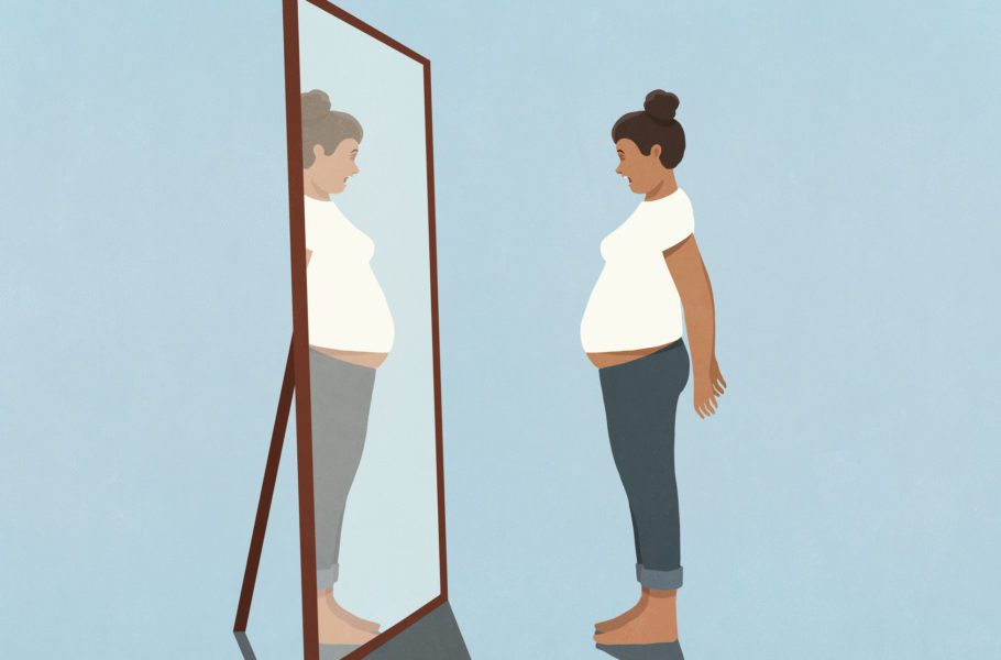Woman looking at large stomach in mirror