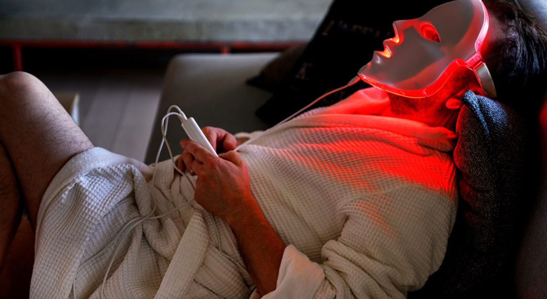 Mature man, during quarantine, trying a light therapy mask at night, Quebec, Canada