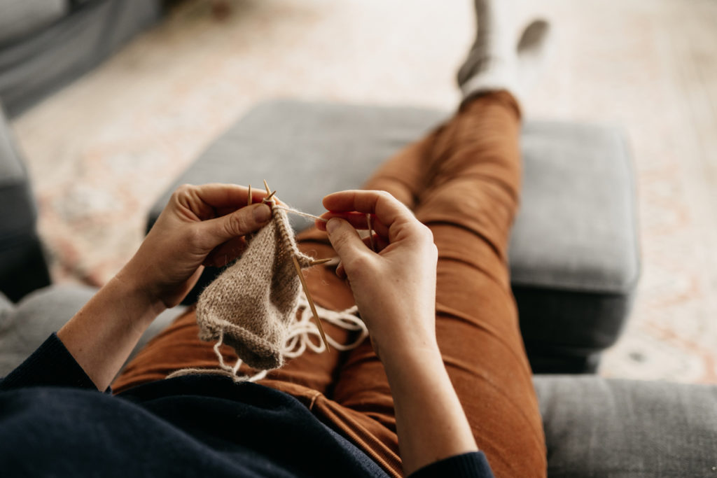 woman knitting in couch