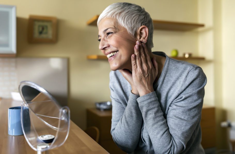 Mature woman aging. Impressed with the results of her anti-aging cream