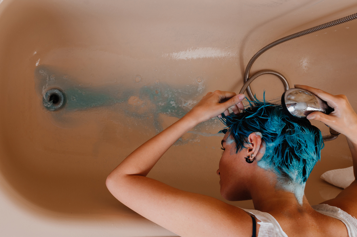 Woman washing her hair after having it blue at home