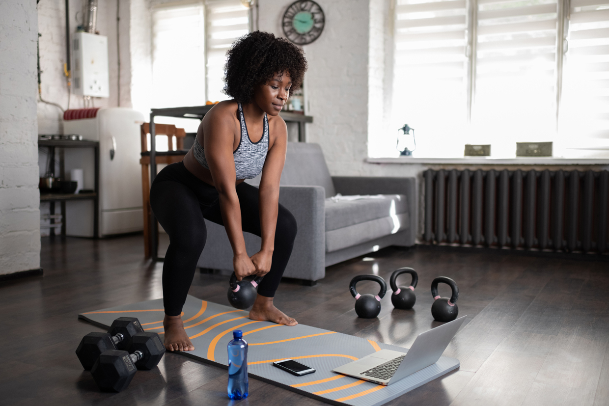 woman lifting kettlebell during online training