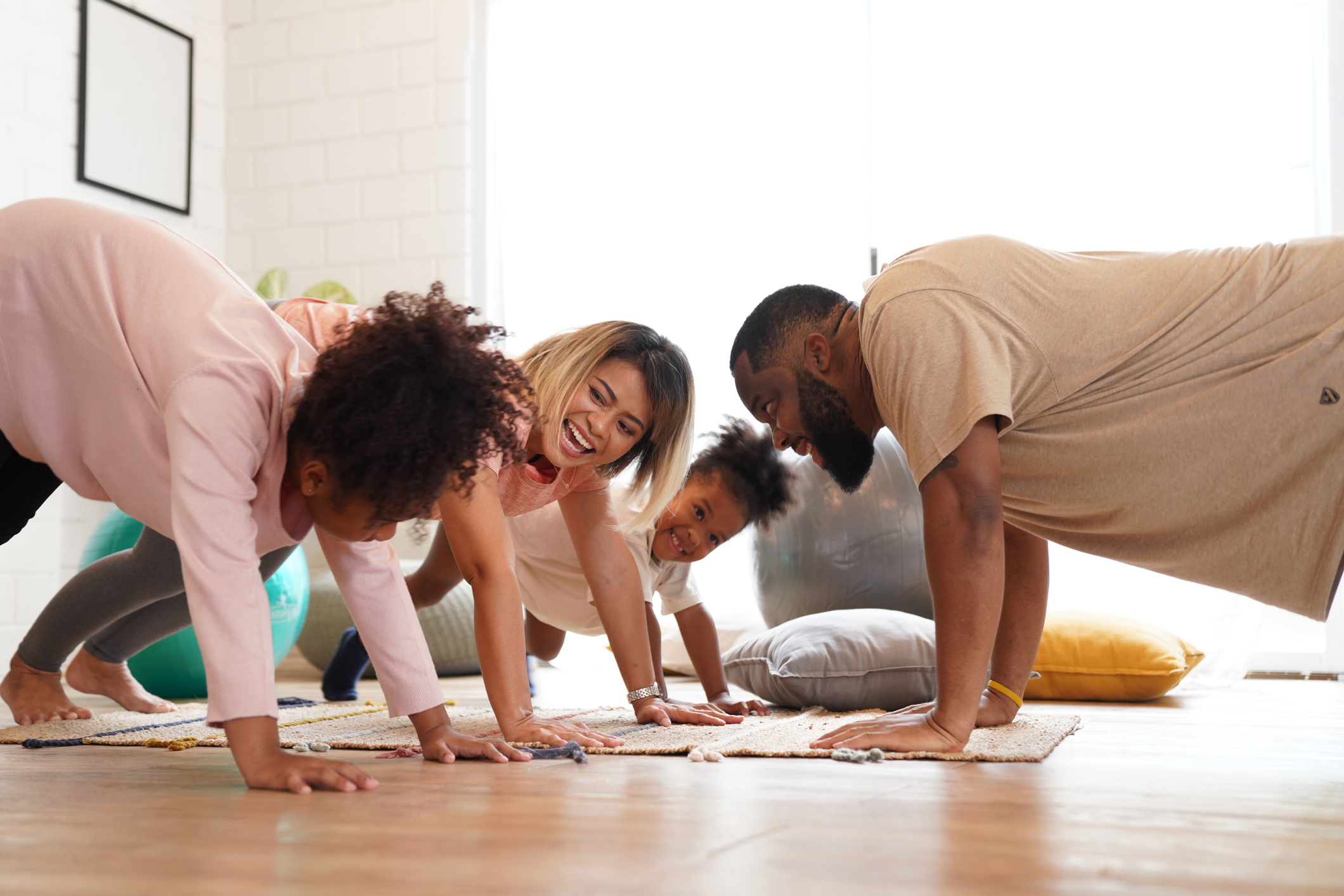 family cheerful laughing exercise together at room 