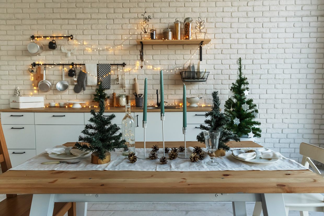 TitleNew Year and Christmas. Festive kitchen in Christmas decorations. Candles, spruce branches, wooden stands, table laying.