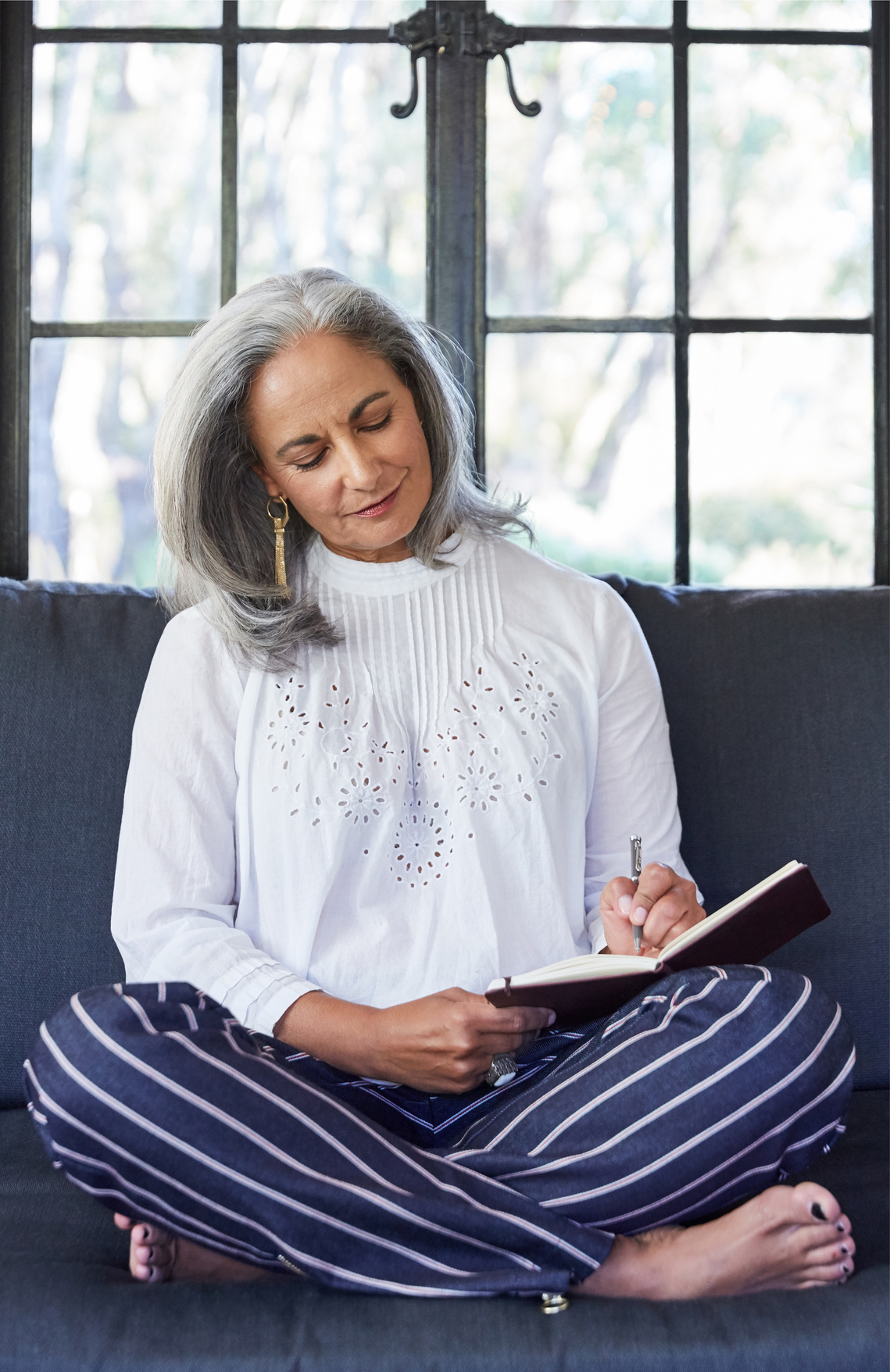woman sitting in couch writing in journal