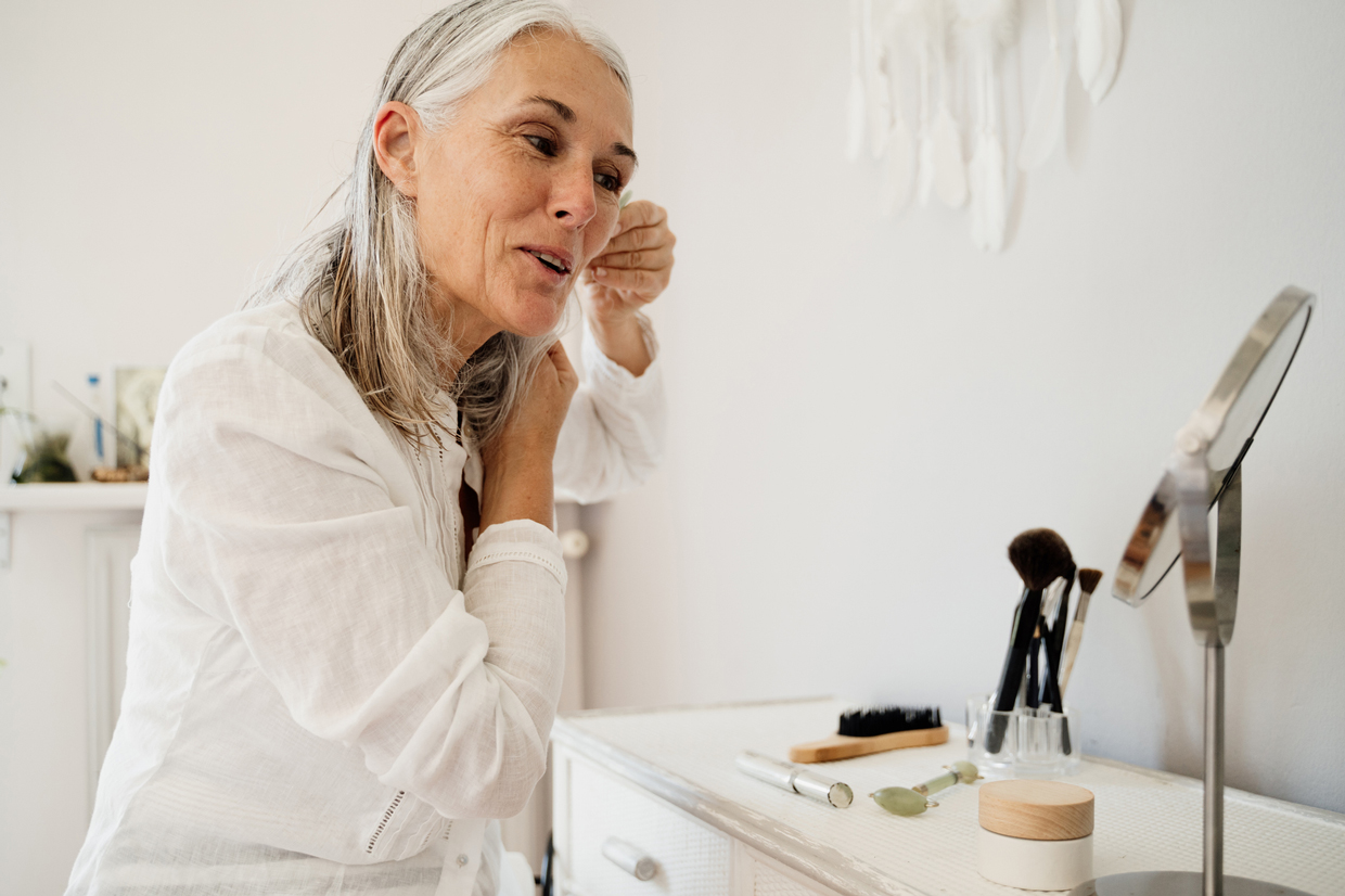 woman doing skin care in mirror at home