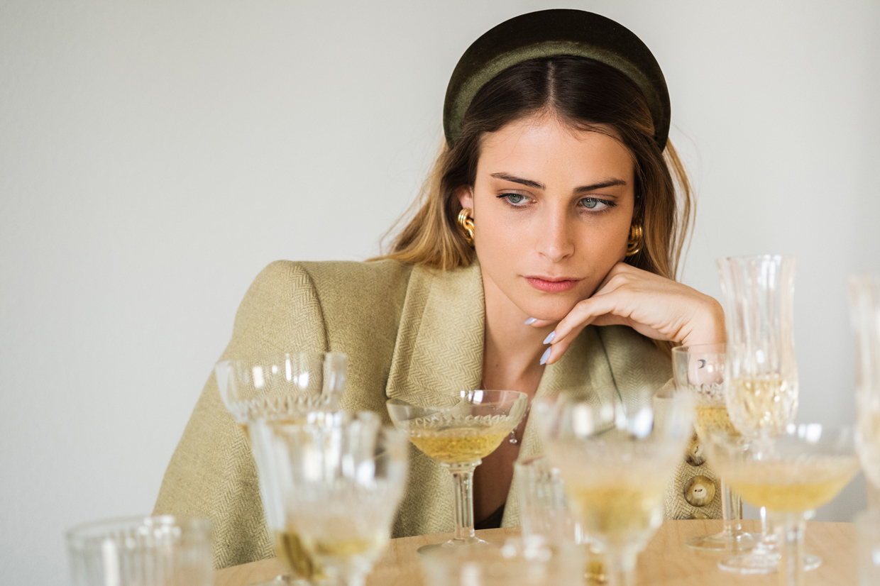 Portrait Of A Young Woman Behind Several Glasses Of Wine