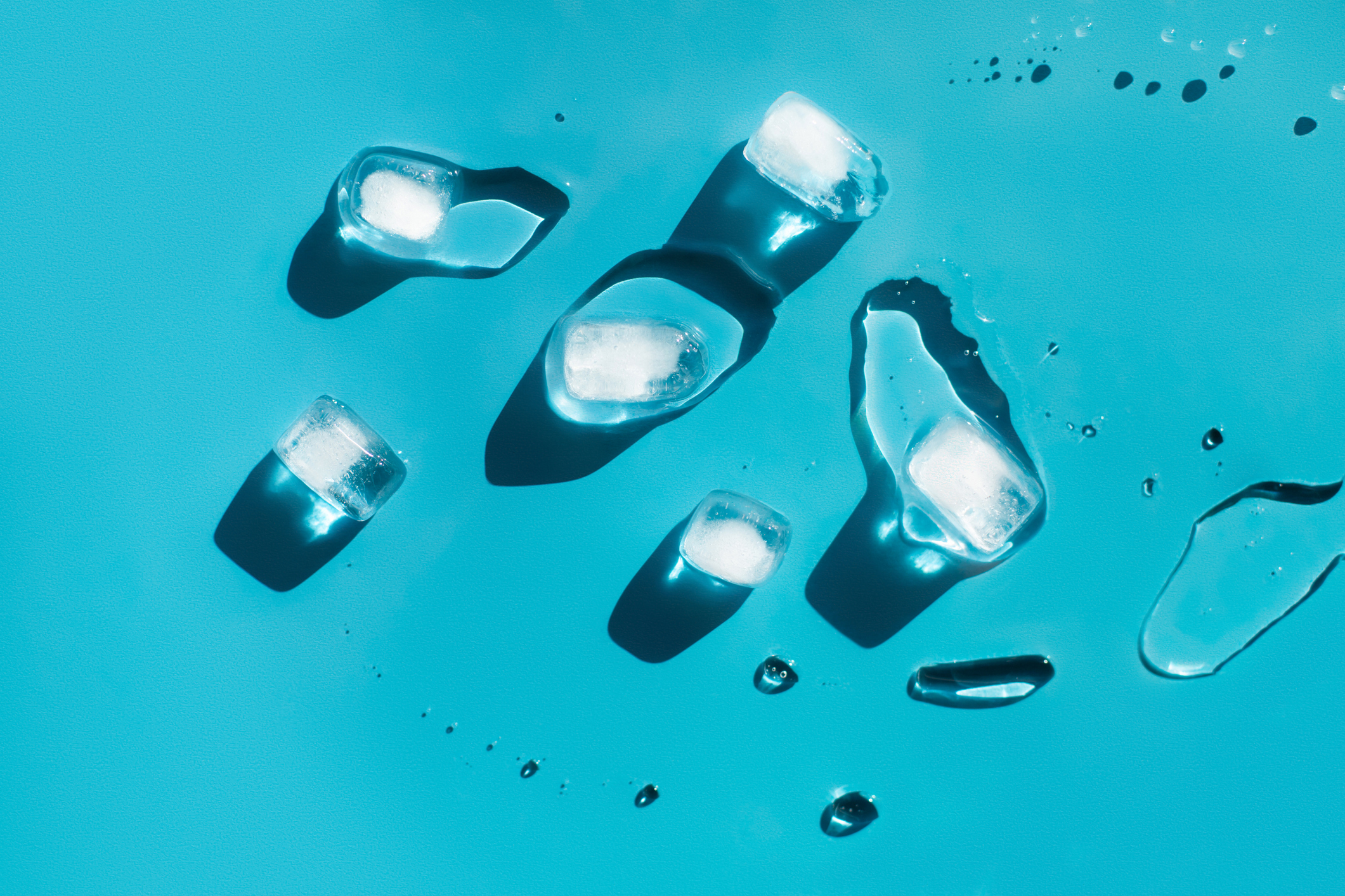 ice cubes melting on blue background