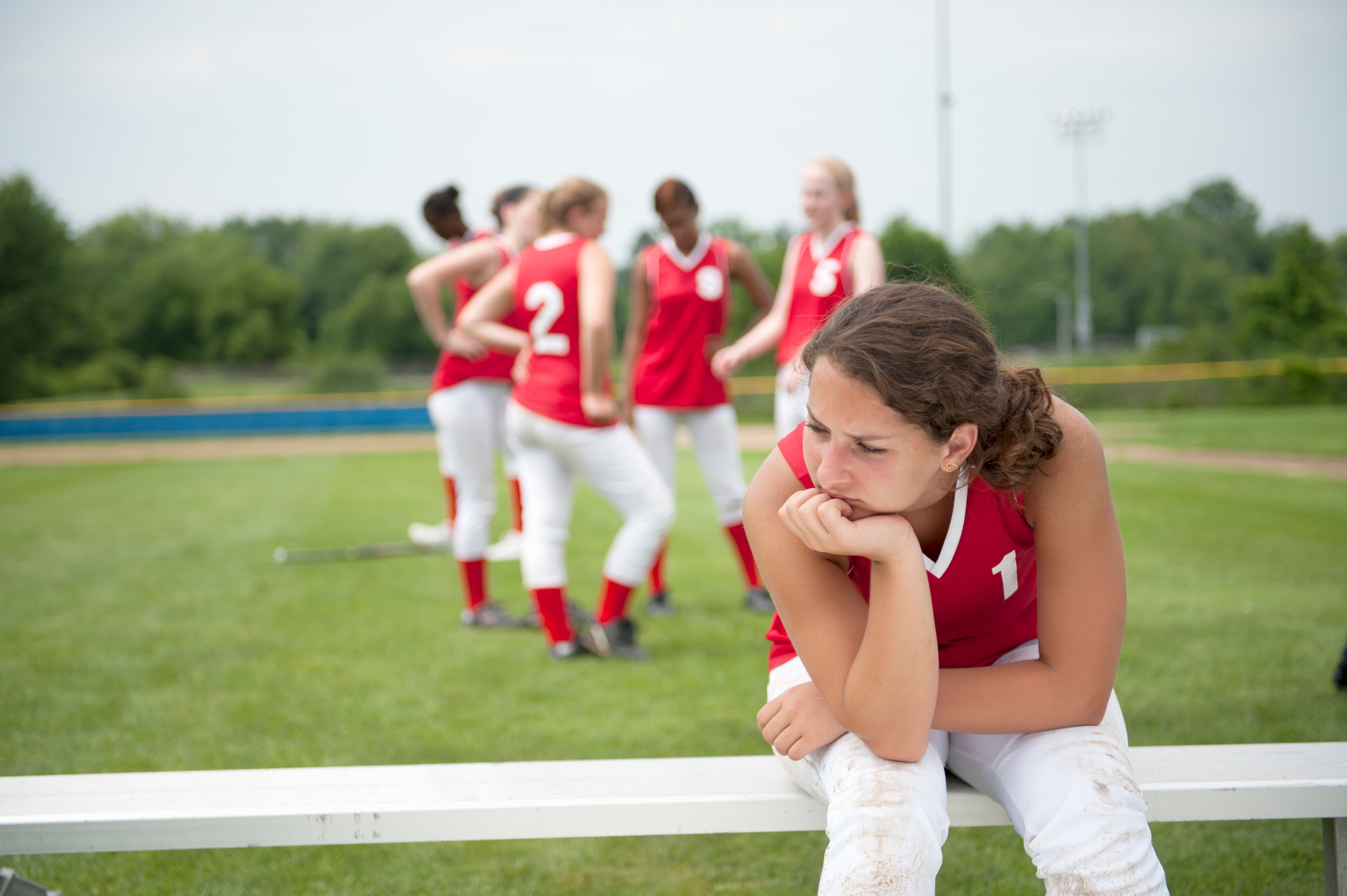 Softball Player Sitting on Bench with head down