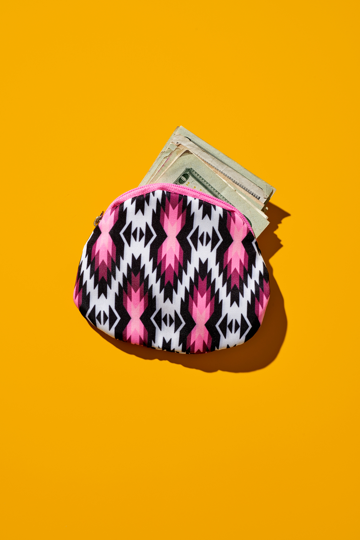 wallet full of money on yellow background