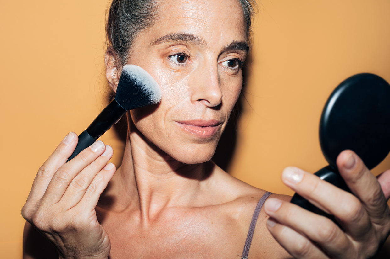 woman applying makeup with makeup brush