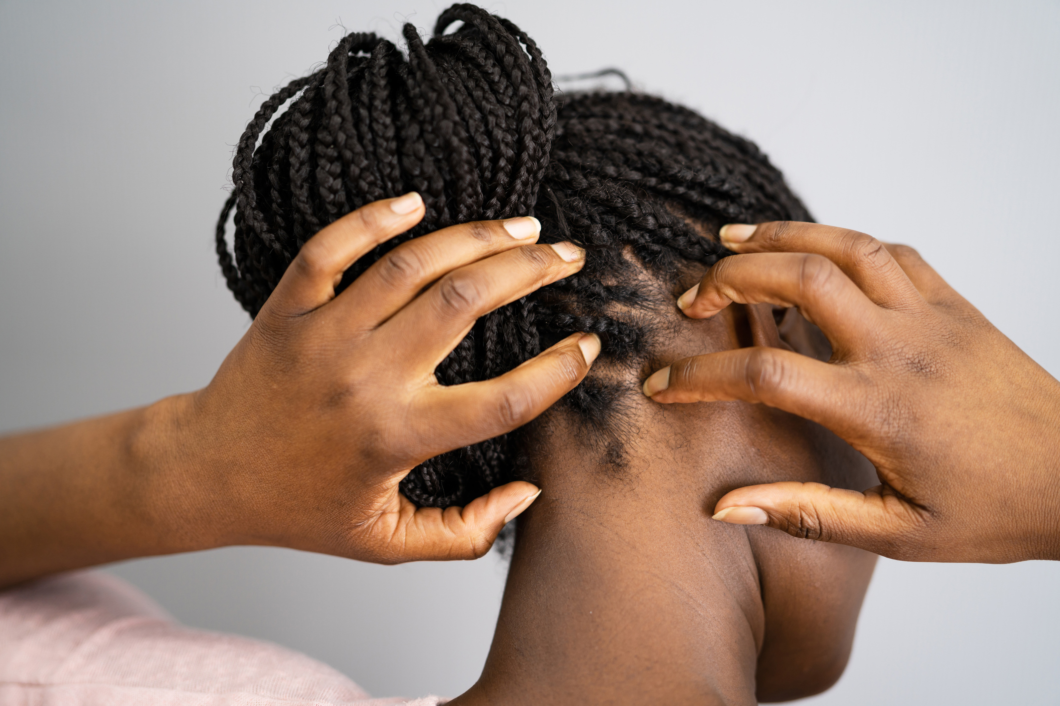 woman with braids scratching scalp