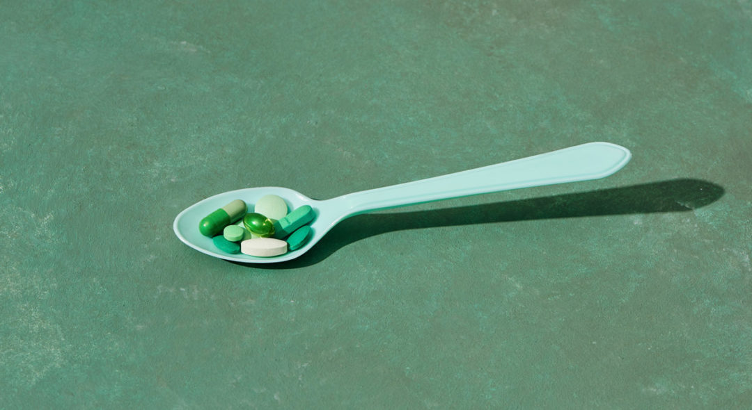 Medicine pills, tablets and capsules on table spoon
