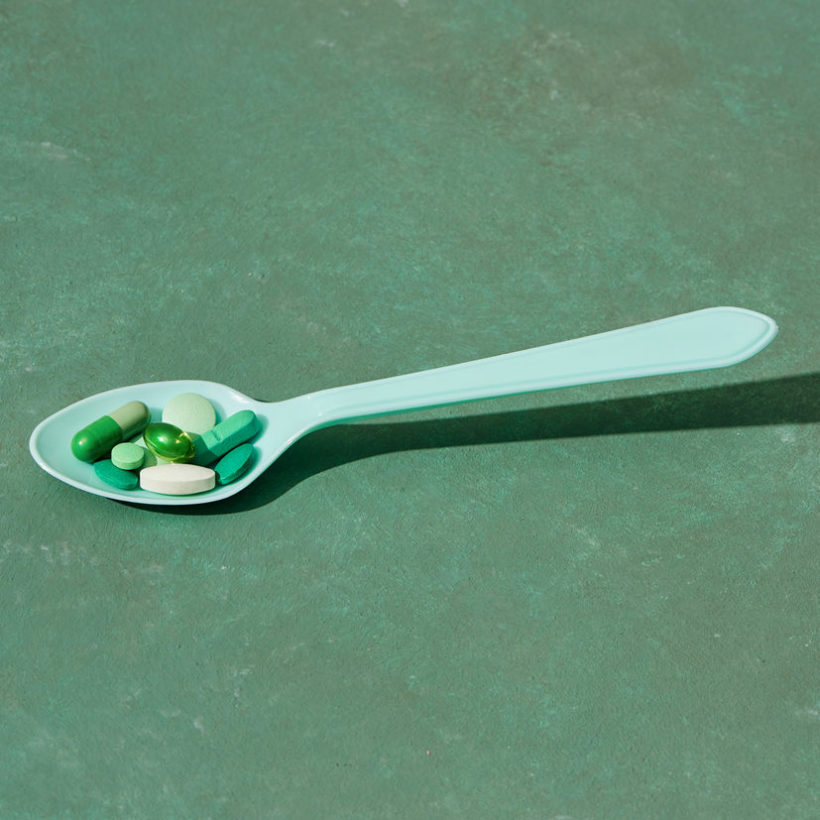 Medicine pills, tablets and capsules on table spoon