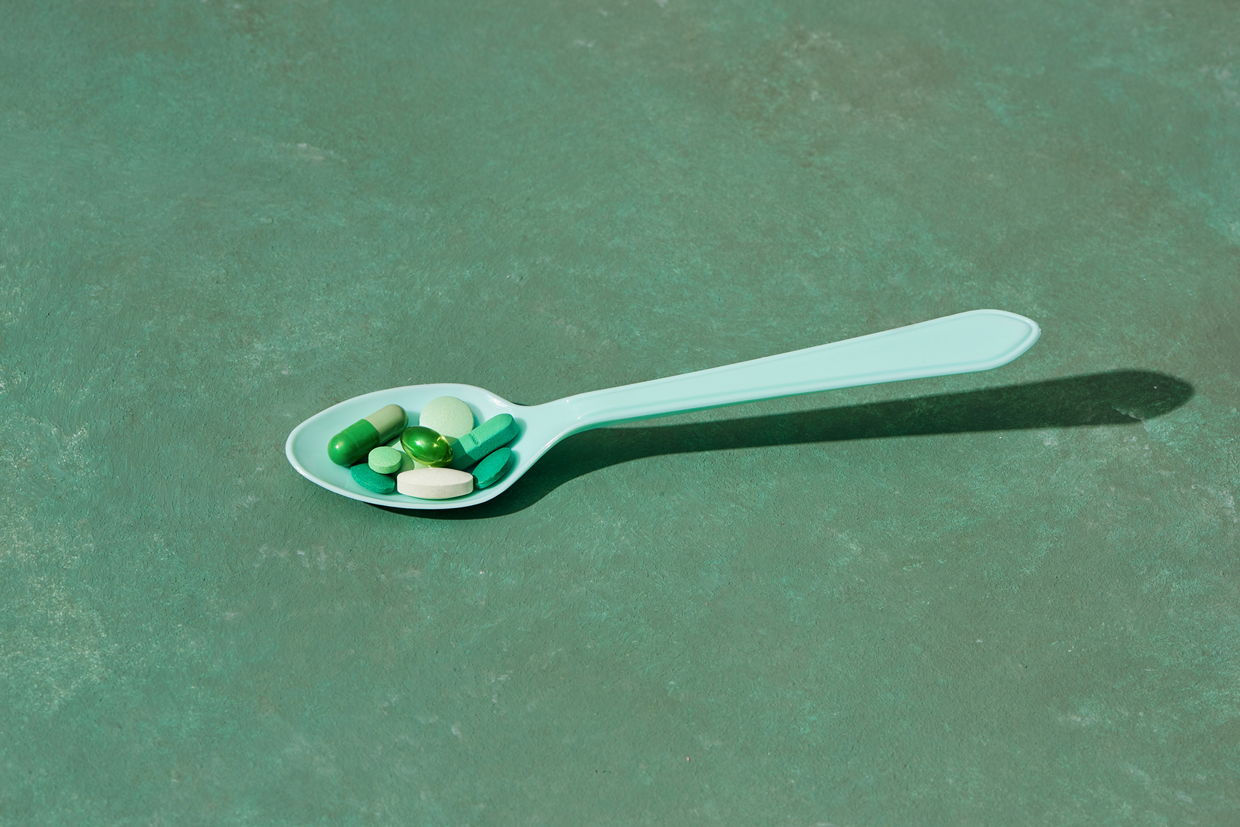 Medicine pills, tablets and capsules on table spoon