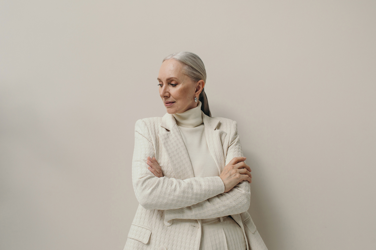 in studio shot of woman with gray hair wearing all white