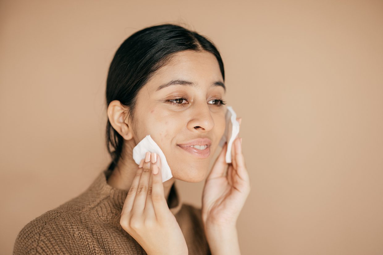 woman applying compress on face