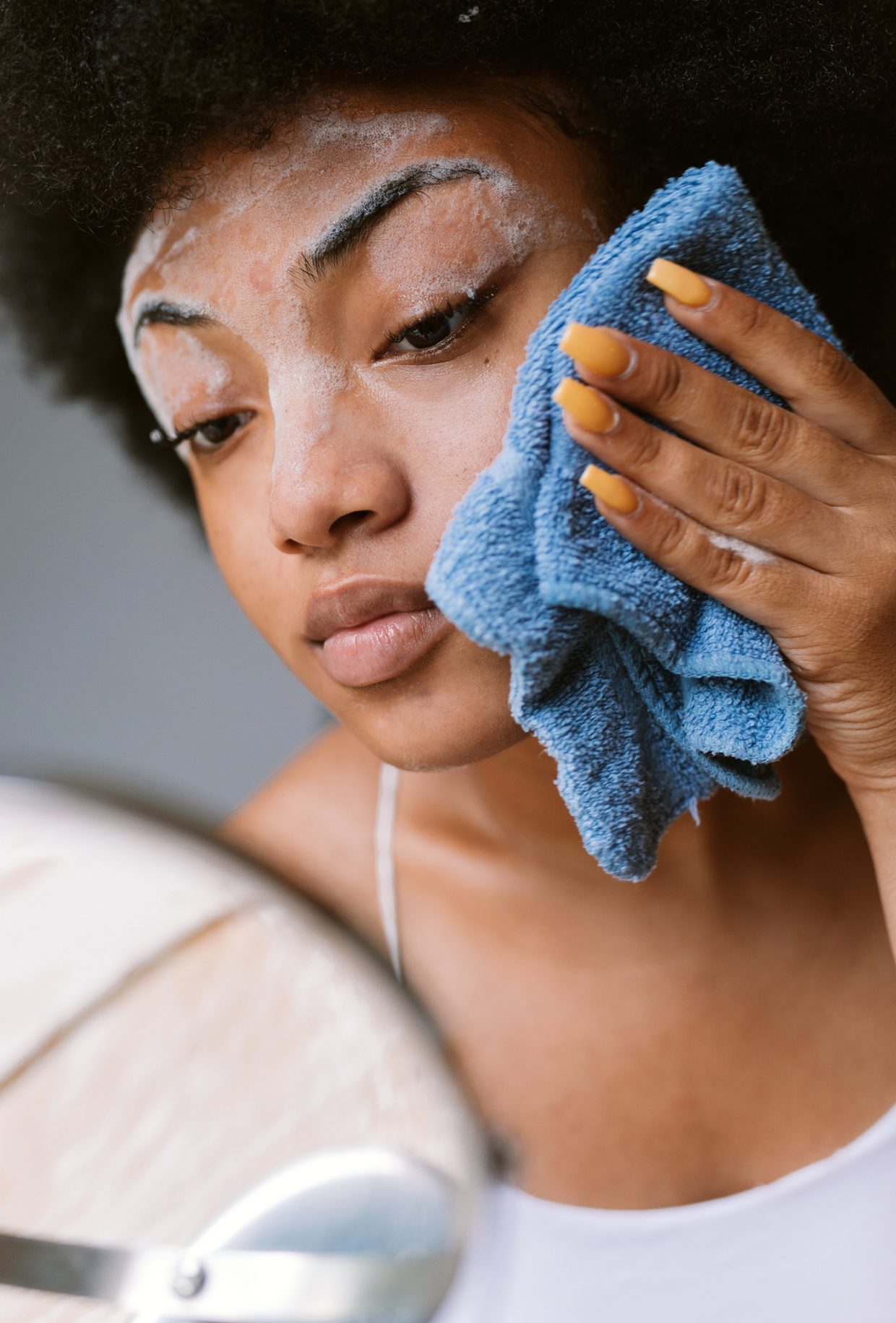 woman washing face with washcloth