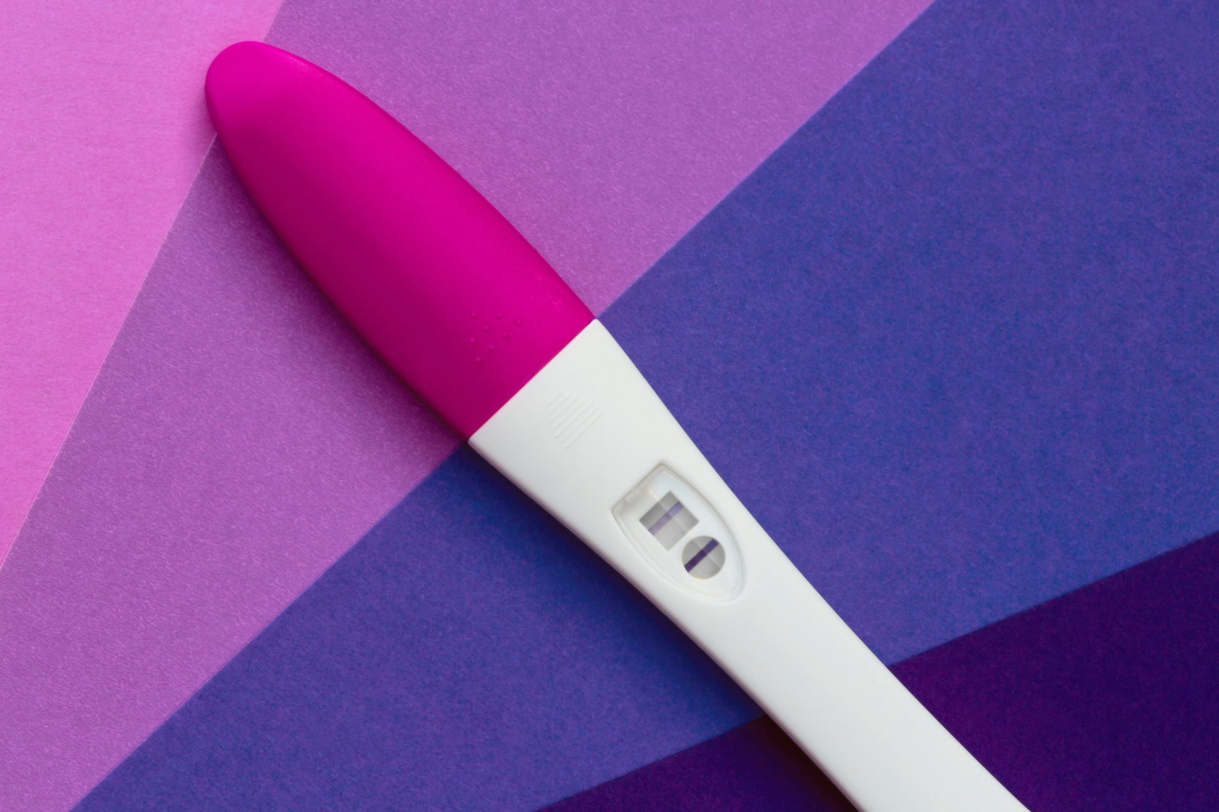 Positive pregnancy test on a gradient background