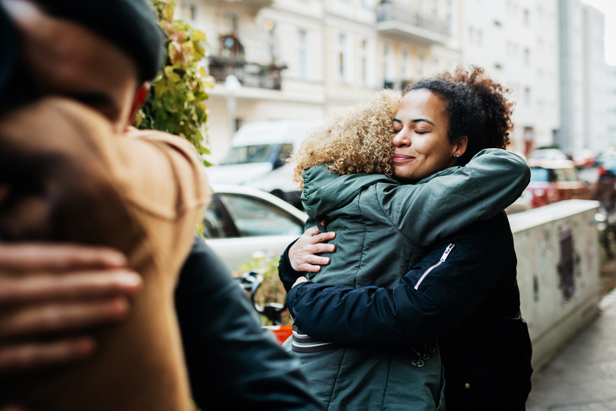 friends hugging in the street