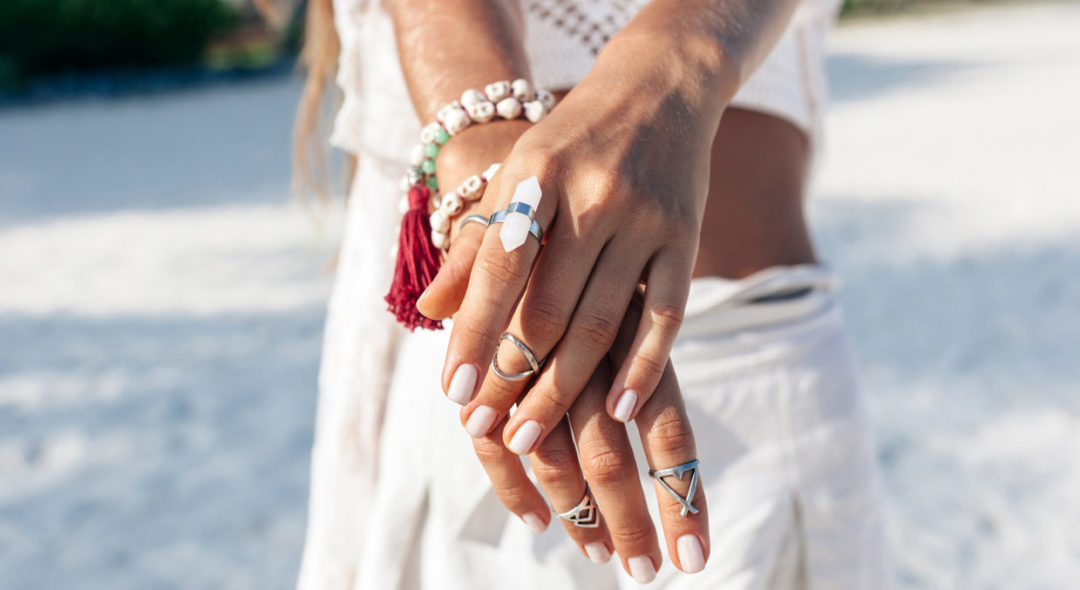 closeup of woman's hands with rings on beach