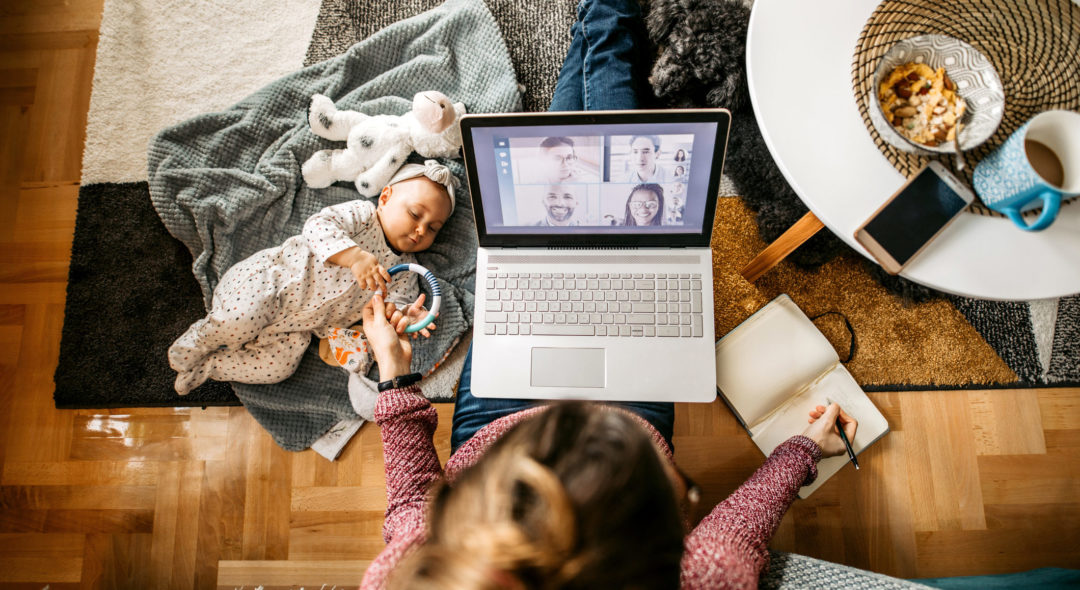 mother with a baby and a dog, sitting on the floor and working
