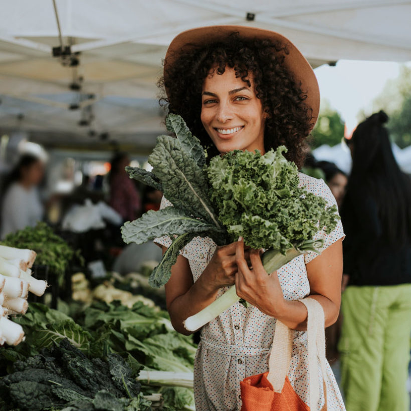 woman buying kale at a farmers market