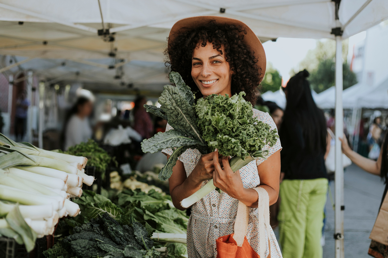 woman buying kale at a farmers market