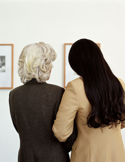 Two women looking at art exhibit