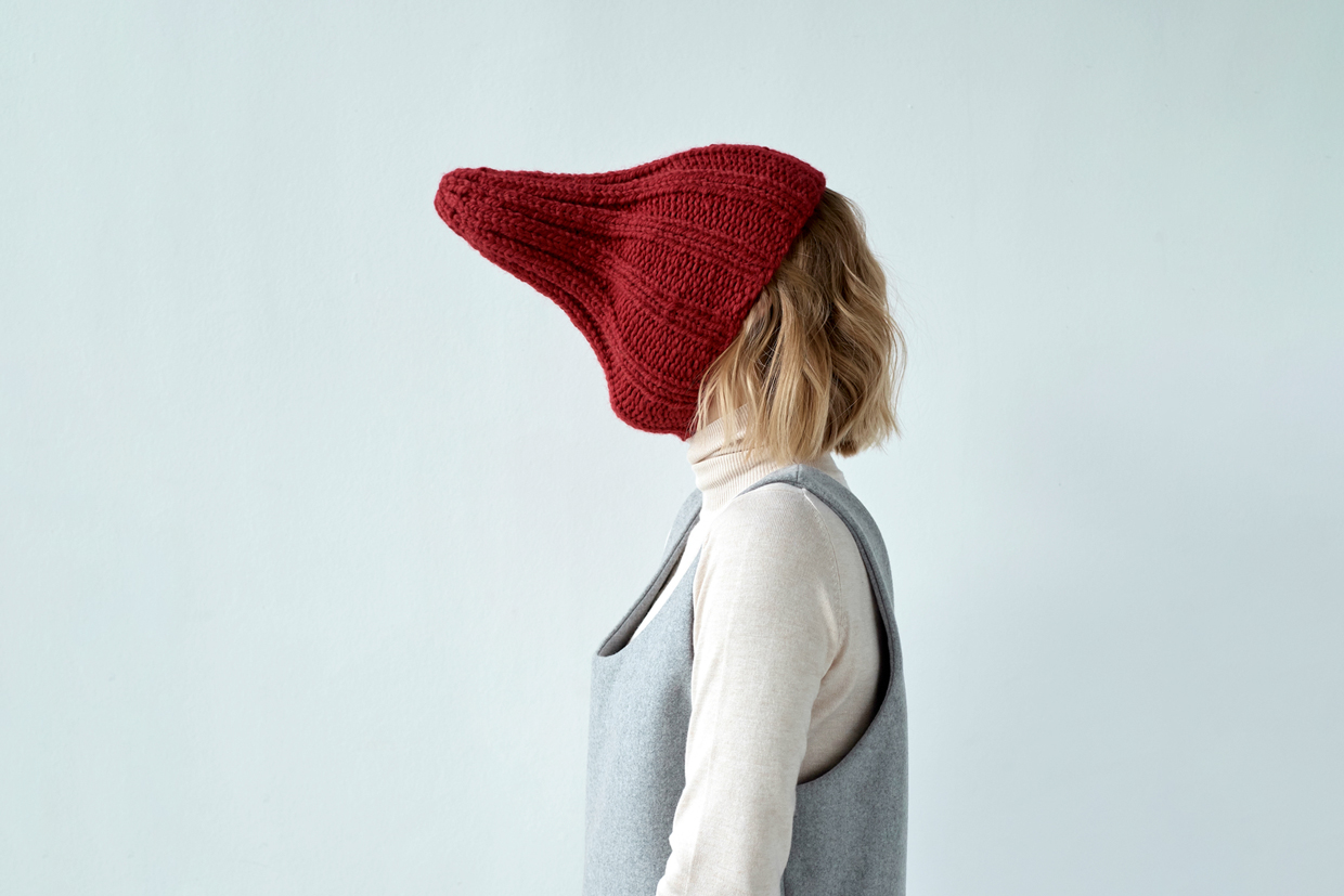 Woman hiding face with knit hat
