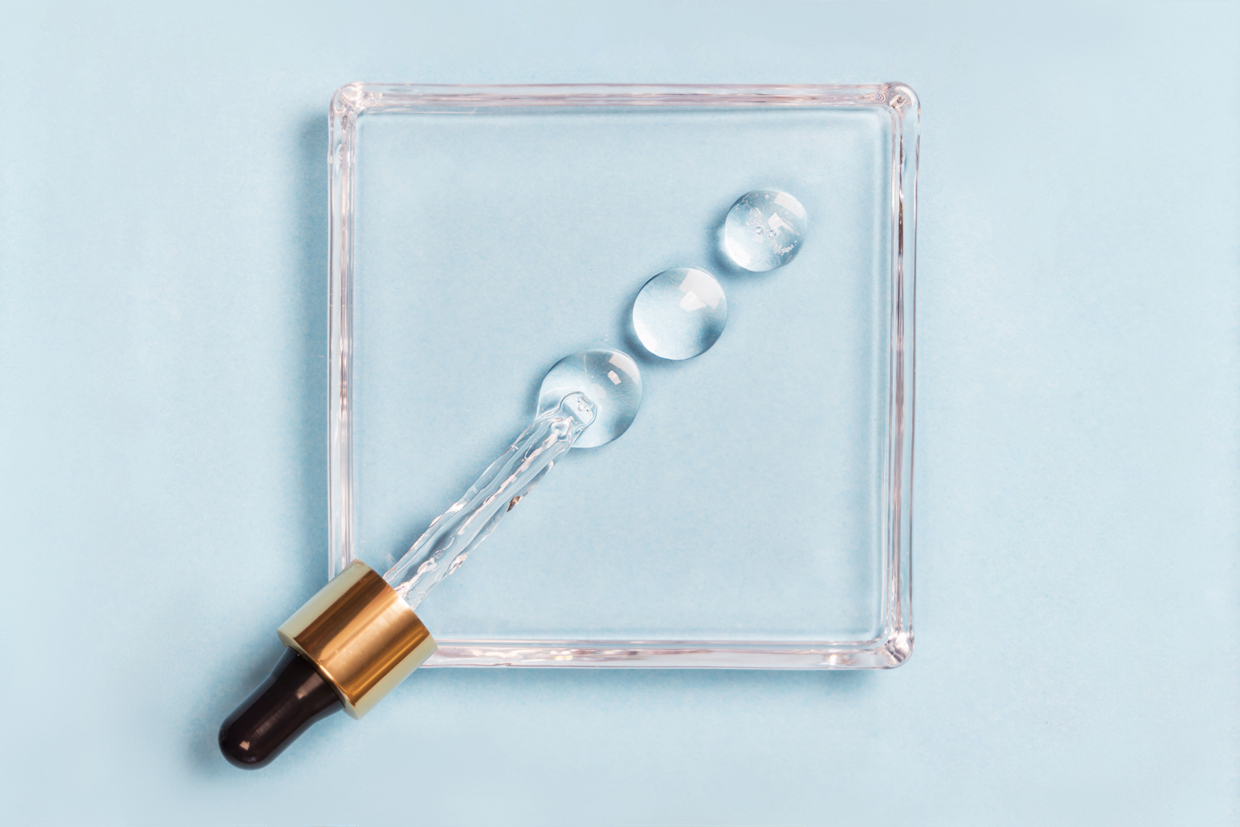 Drops of serum on a blue background medical concept Oxygen filled fluid