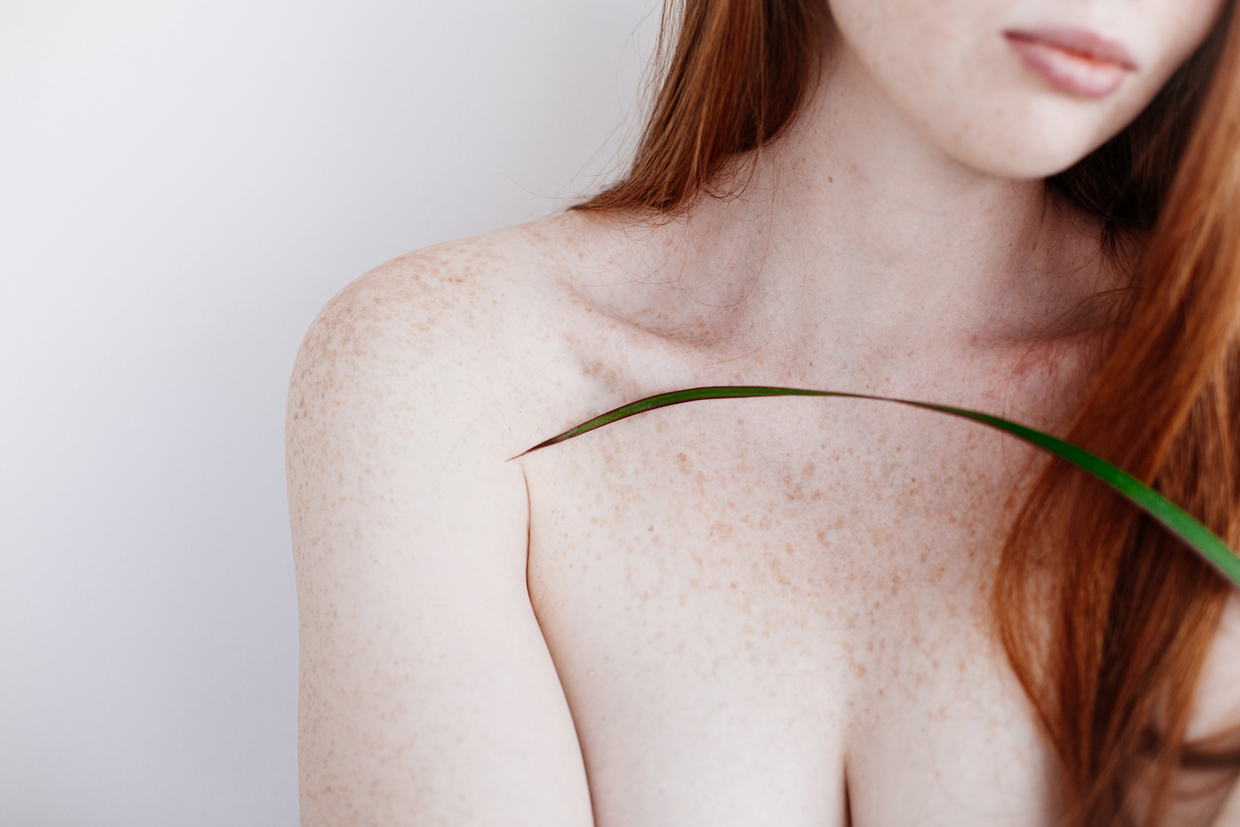 close up of red haired woman with freckles on body