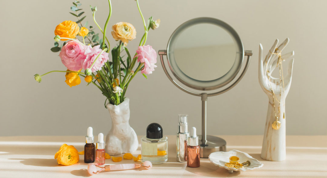 Mirror and cosmetic products on table at home
