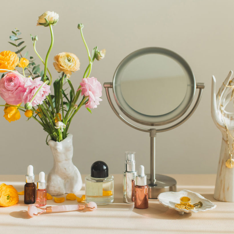 Mirror and cosmetic products on table at home