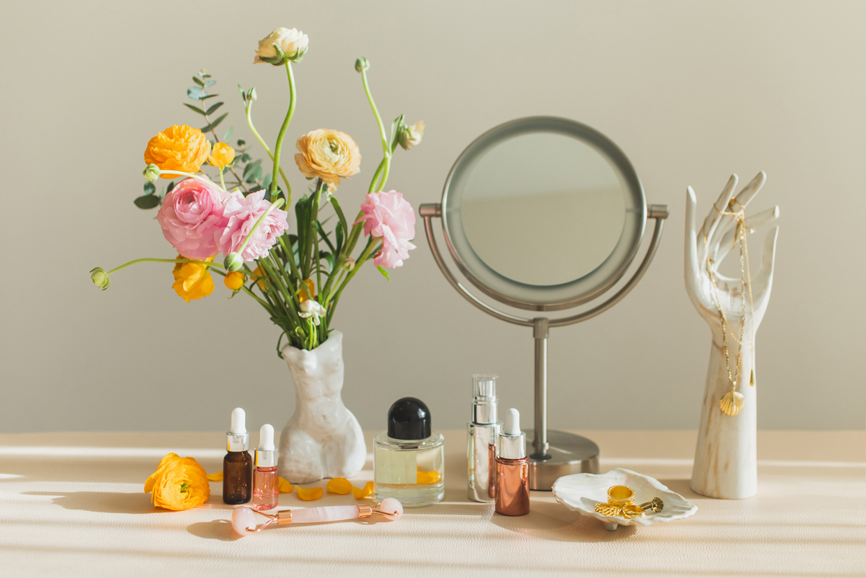 Mirror and cosmetic products on table at home