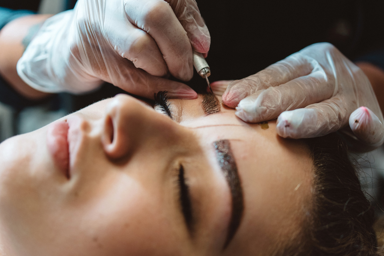 woman getting eyebrows microblading