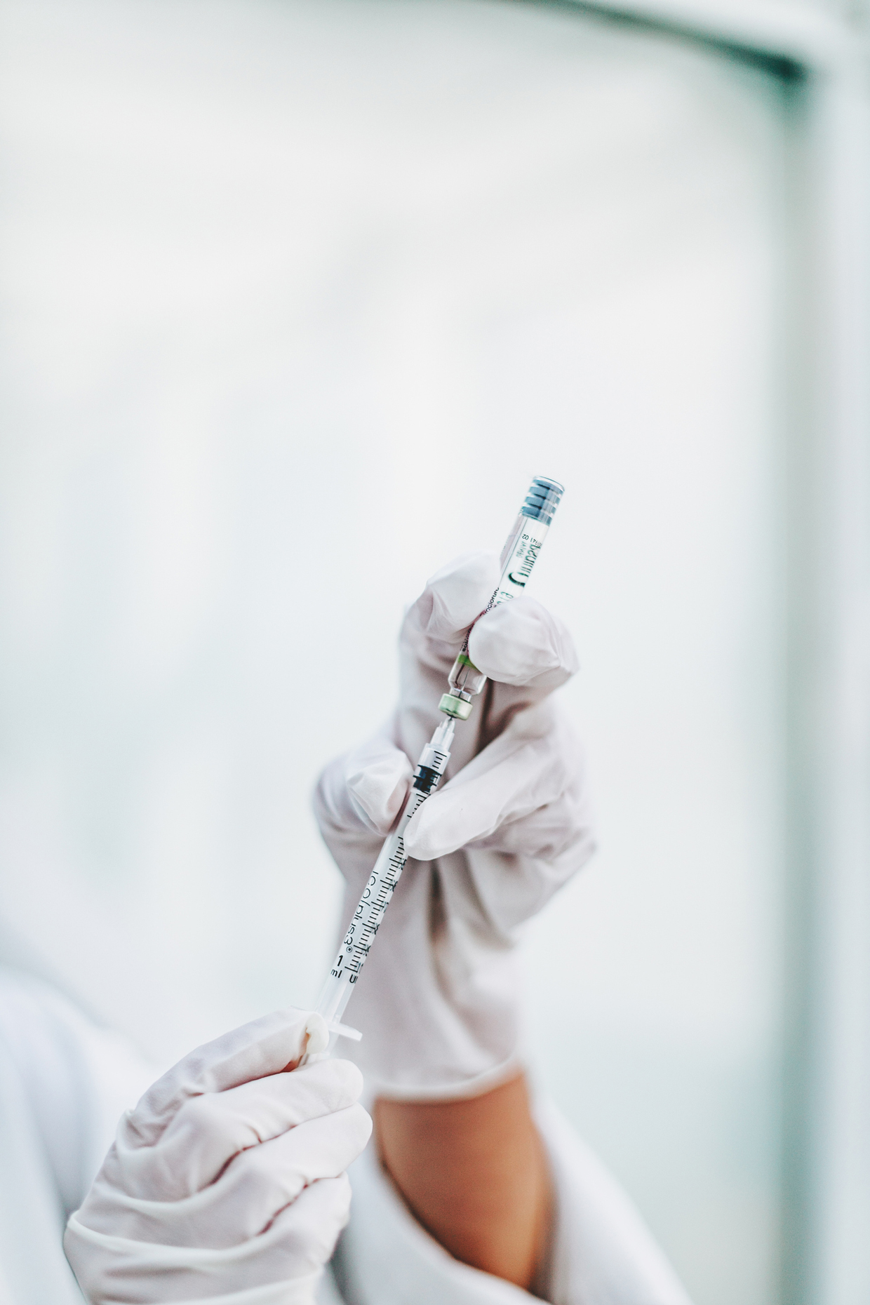 hands with gloves holding injection